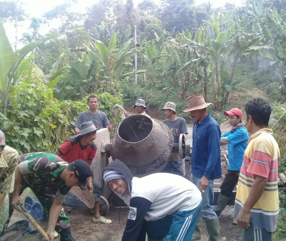 Babinsa Desa Sirnajaya bersama Warga Desa Gunung Sintok mengecor Jalan desa Binaannya