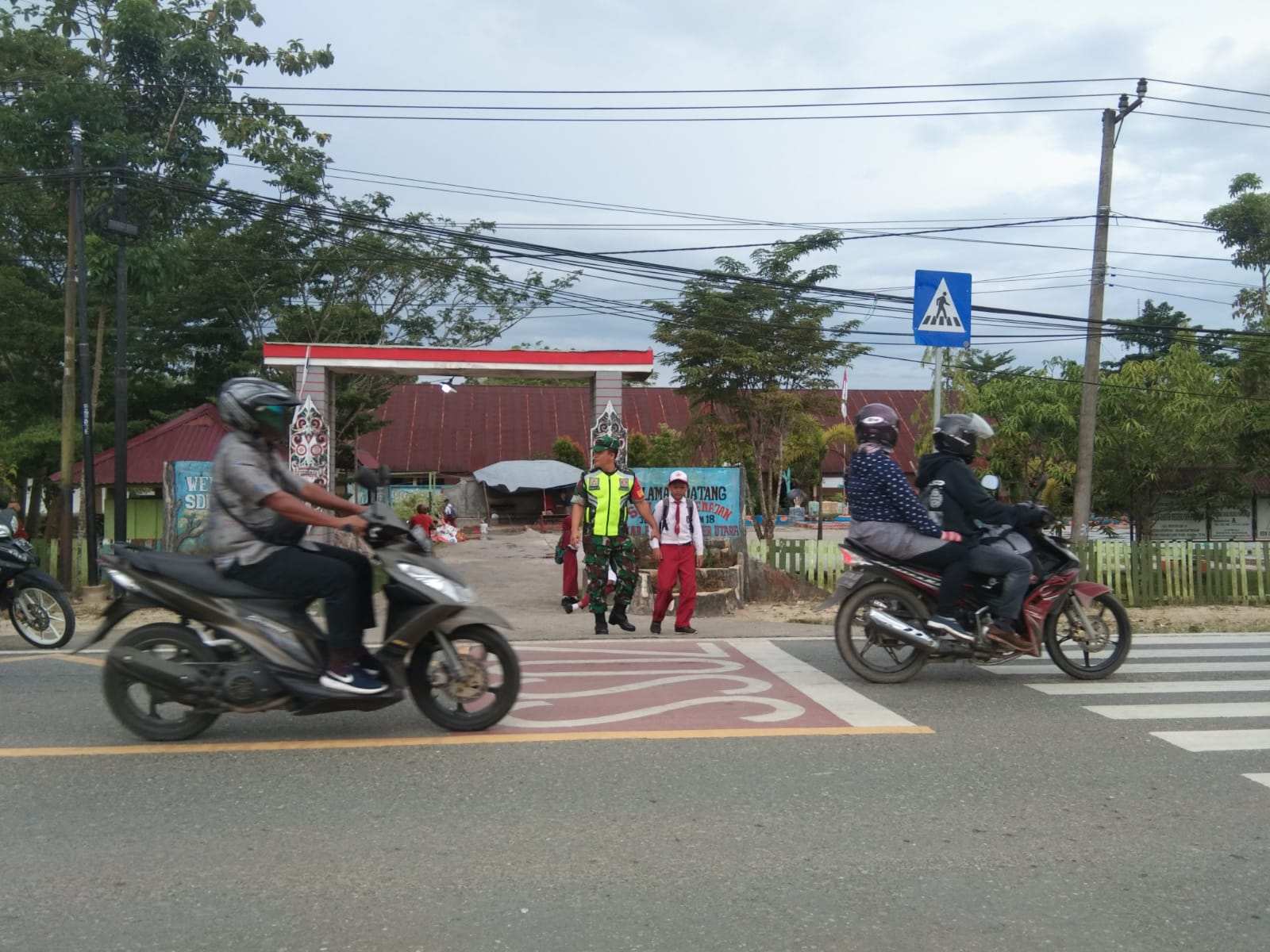 Kepedulian, Babinsa Koramil Penajam Bantu  Seberangkan Anak Sekolah