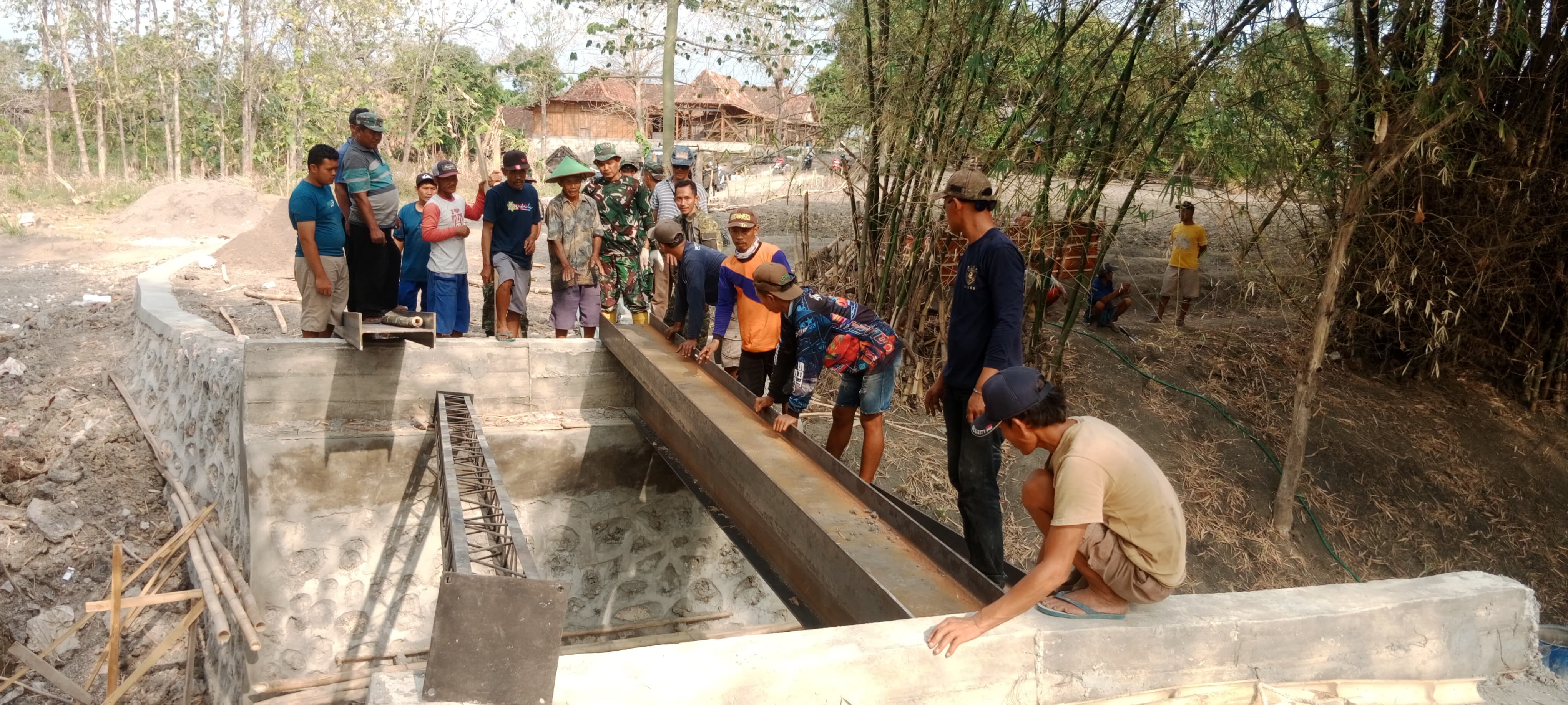 TNI dan Warga Desa Pelem Gotong Royong Pasang Besi Jembatan TMMD